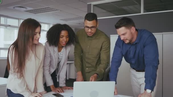 オフィスデスクのコンピュータでチームワークで一緒に働く幸せな若い多民族ビジネスチーム — ストック動画