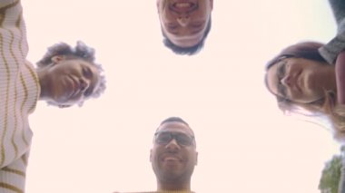 Farklı genç arkadaşların başlarını bir araya getirerek gülümseyip sarılarak düşük açı görünümü