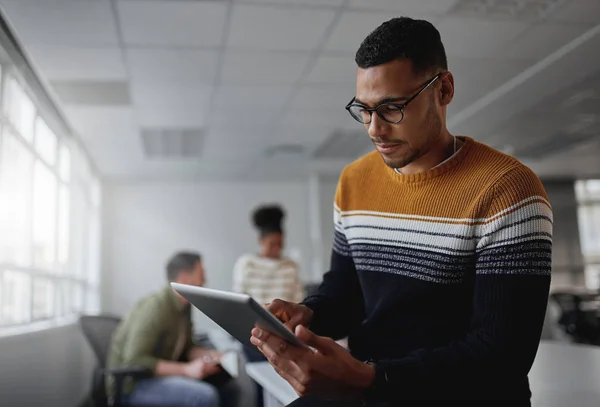 Geconcentreerde jonge slimme zakenman in casual slijtage bezig met het gebruik van digitale tablet op kantoor — Stockfoto