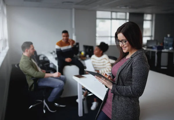 Amerikaanse zakenvrouw met behulp van digitale tablet per bureau met collega's bespreken in de achtergrond bij Office Startup ondernemer — Stockfoto