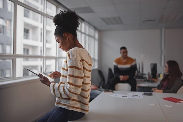 Una joven empresaria afroamericana que trabaja en tableta digital con el equipo empresarial brasileño comunicándose en segundo plano — Foto de Stock