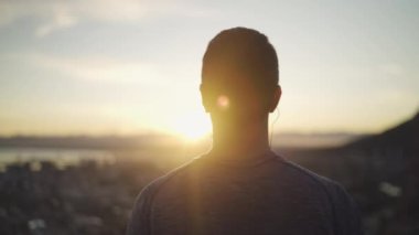 gündoğumu ilham manzara bakarak kulaklarında kulaklık ile atletik bir fitness adam arka görünümü yakın çekim - gündoğumu hayran adam