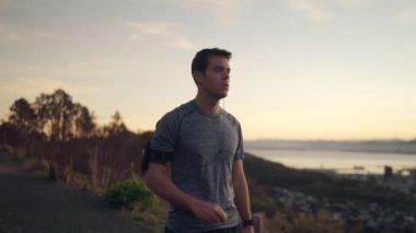Fitness koşucusu kol bandı kayışı cep telefonu müzik dinlerken dağ tepesinde çalışan - erkek atlet çalışan - cityscape