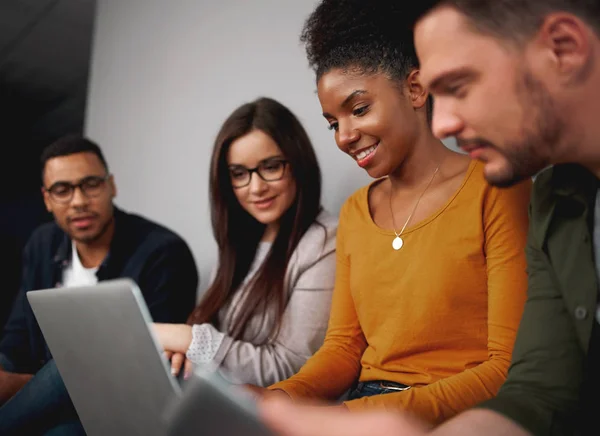 Sonriendo amigos diversos redes sociales en un ordenador portátil agrupados juntos leyendo la información más reciente en la pantalla — Foto de Stock