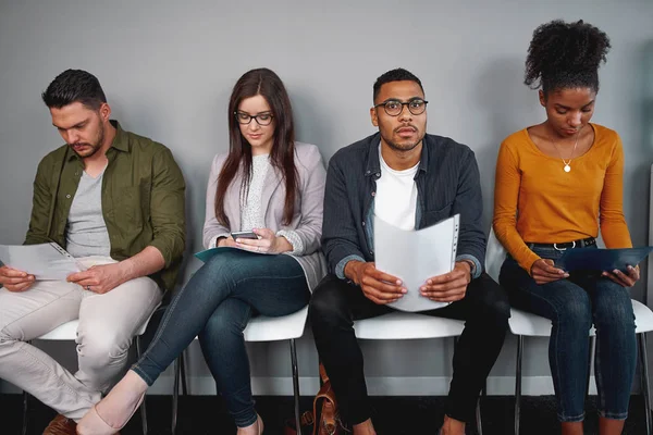 Groupe de jeunes candidats multiraciaux en attente d'une entrevue assis sur la chaise tenant leur curriculum vitae — Photo