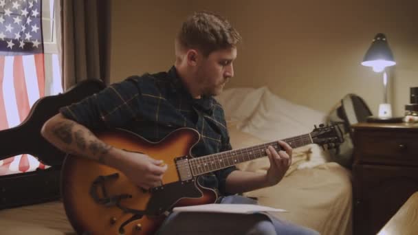 Smiling songwriter thinking and writing notes, paroles dans le livre tout en jouant de la guitare acoustique à la maison - idées novatrices — Video