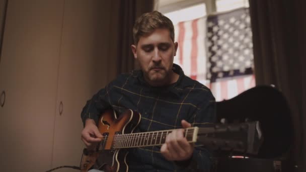 Portrait of a young man singing while playing acoustic guitar at home — Stock Video