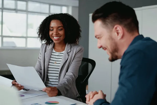 Twee verschillende jonge vrolijke zakenmensen in formele kleding die het project op de werkplek bespreken — Stockfoto