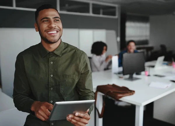 Retrato de um jovem empresário criativo segurando tablet digital na mão sorrindo e olhando para longe — Fotografia de Stock