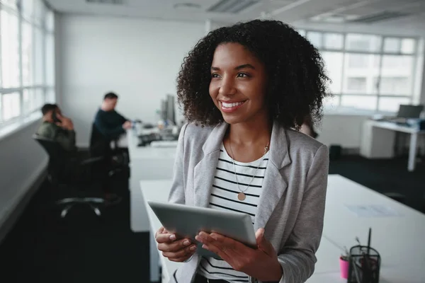 Портрет дружньої успішної молодої чорношкірої бізнес-леді тримає цифровий планшет в руці, дивлячись в офіс — стокове фото