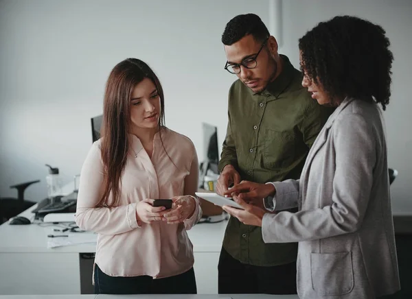 Groep multi-etnische jonge geconcentreerde ondernemers die digitale tablet op de werkplek gebruiken — Stockfoto