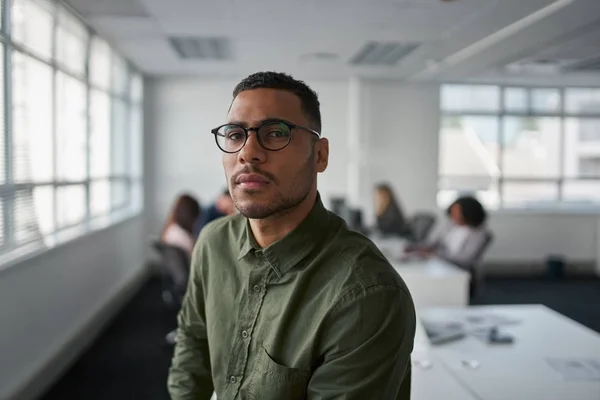 Retrato de um jovem empresário profissional sério usando óculos olhando para a câmera enquanto colega de fundo — Fotografia de Stock