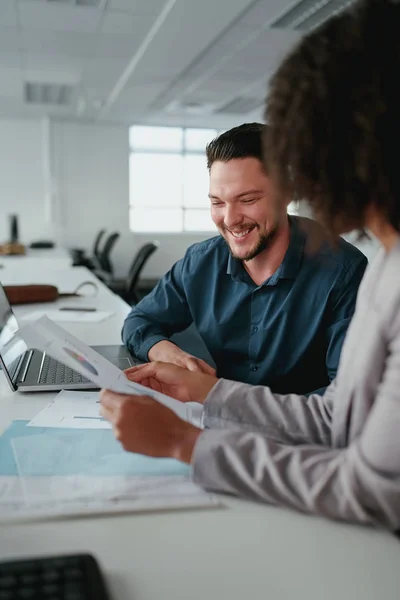 Close-up van een lachende jonge zakenman die met zijn vrouwelijke collega werkt aan een nieuw opstartproject — Stockfoto