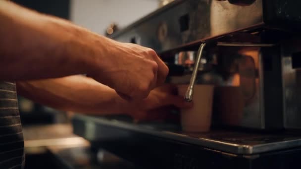 若い男性シェフの手の選択的な焦点は、テイクアウトカップで新鮮なコーヒーを作り、顧客に与える — ストック動画