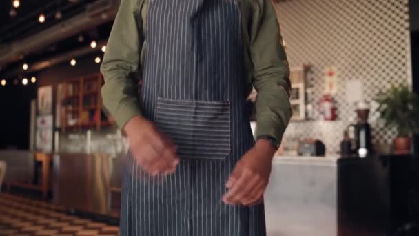 Portret van een succesvolle Afrikaanse chef-kok in een zwart schort met gevouwen armen in café tegen de toonbank — Stockvideo
