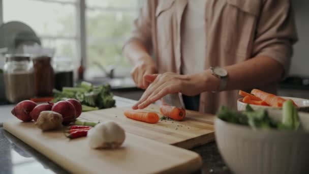 Primer plano de una chica bloguera de alimentos cortando las zanahorias en la tabla de cortar en casa en la cocina durante el período de cierre — Vídeos de Stock