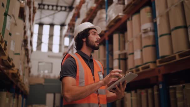 Retrato de empresário masculino em chapéu branco usando tablet digital em armazém — Vídeo de Stock