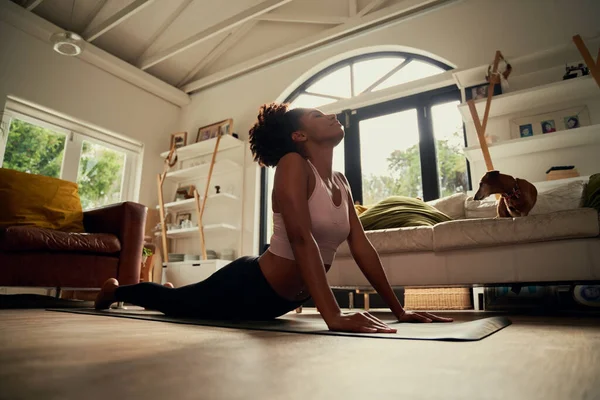 Visão de baixo ângulo da jovem africana fazendo exercício de alongamento no tapete de ioga em casa — Fotografia de Stock