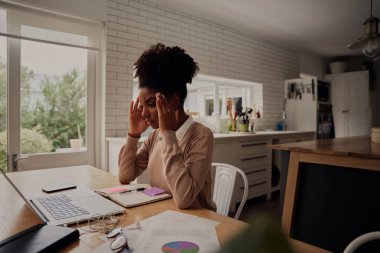 Genç stresli kadın bilgisayarın önünde otururken el ele tutuşuyor.