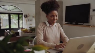 Tecrit sırasında laptopla ev ofisinde çalışırken alnına masaj yapan Afrikalı Amerikalı genç bir kadın.