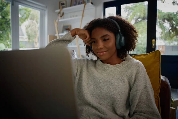 笑顔若いアフリカの女性を見てウェブセミナーノートパソコンでともにヘッドフォンで自宅 — ストック写真