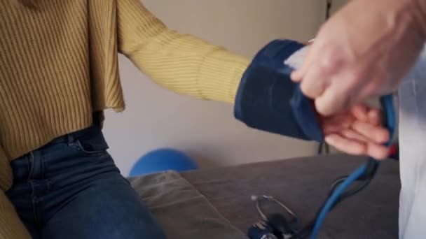 Nahaufnahme eines männlichen Arztes, der einem Patienten den Blutdruck abnimmt — Stockvideo