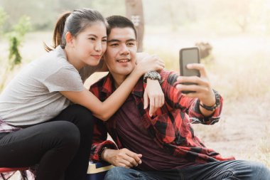 Çift, selfie çekmek için akıllı telefon kullanıyor.