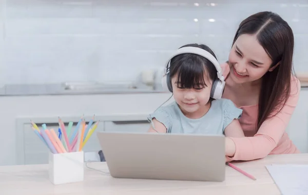 Asyalı anneler ve kızlar internet üzerinden bilgisayar kullanarak ve kulaklıkla sesi dinleyerek internetten öğreniyorlar.