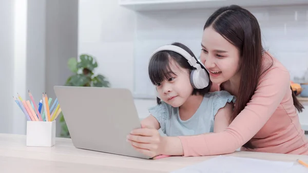 Asyalı anneler ve kızlar internet üzerinden bilgisayar kullanarak ve kulaklıkla sesi dinleyerek internetten öğreniyorlar.