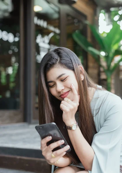 Akıllı telefon kullanan kadınlar Neşeli bir gülümsemeyle