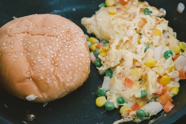 Omlet ve Burger unu siyah bir tavada kızartılıyor.