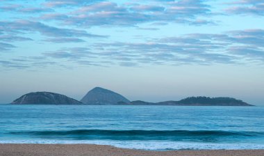 Ipanema plajıdramatik manzara, denize bakarak, sabahın erken saatlerinde, kimse ile su ve gökyüzü mavi tonaliteleri. Rio de Janeiro, Brezilya.