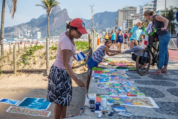 Rio de Janeiro, Brezilya-8 Haziran 2016: sanatçı onun resimleri satış ve Ipanema Beach sokakta turist için çalışıyor