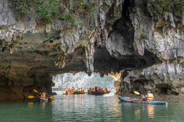 Halong Bay, Vietnam - 24 Aralık 2013: turistlerin mağaralardan geçtiği küçük tekneler