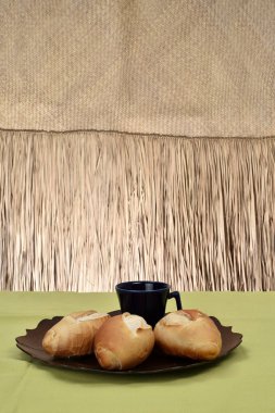 Fransız ekmeği, arka planda siyah fincan ile tabakta