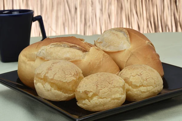 Pão francês assado sobre molho preto com fundo de palha — Fotografia de Stock