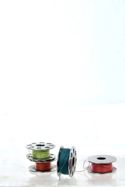 Carrete de metal de hilos de colores sobre fondo blanco con reflecti —  Fotos de Stock