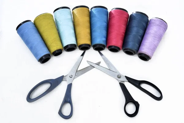 Bobine di filo da cucire colorate su sfondo bianco con forbici — Foto Stock
