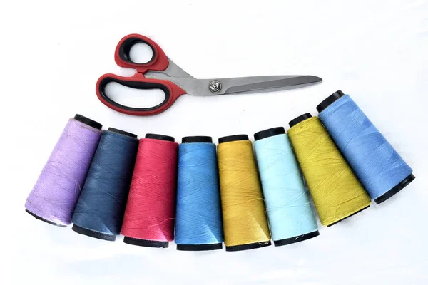 Carretéis de linha de costura coloridos no fundo branco com tesoura — Fotografia de Stock