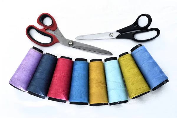 Colorful sewing thread reels on white background with scissors — Stock Photo, Image