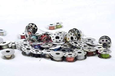 beyaz arka plan üzerinde renkli iplikleri ile metal makara