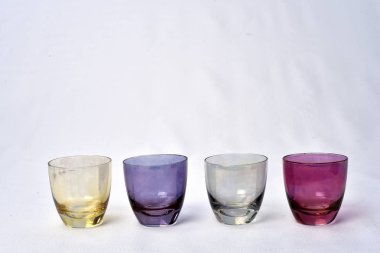 Beyaz arka planda masada renkli içecekler cam bardak