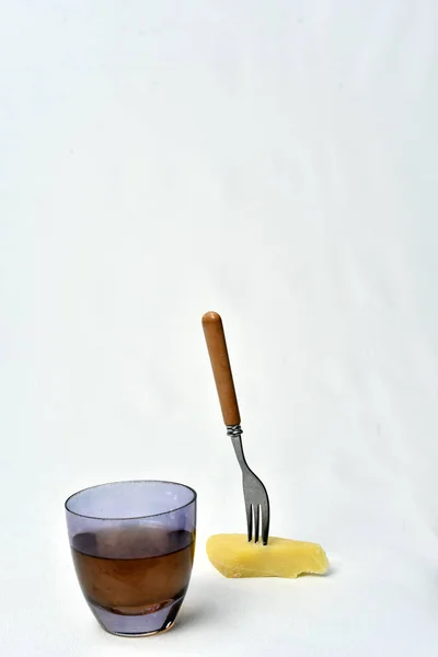 Beyaz backg üzerinde masada peynir ile alkollü içecek bardak — Stok fotoğraf