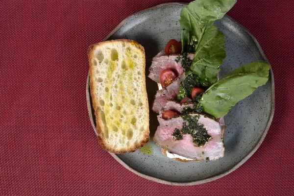 Sandwich au bœuf avec rucula, tomates cerises et pesto — Photo