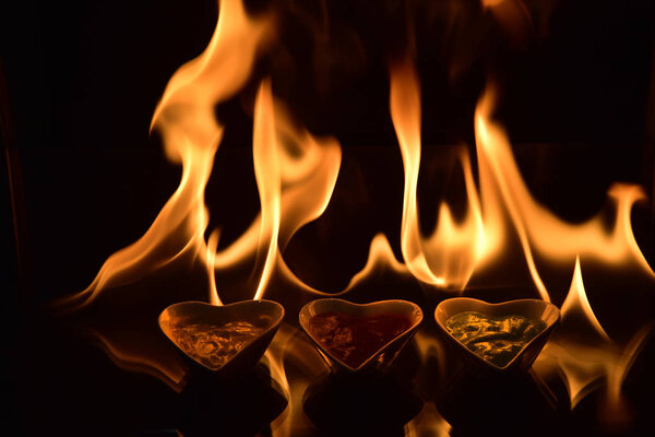 heart shape ceramic bowl with sauces on black background with fi