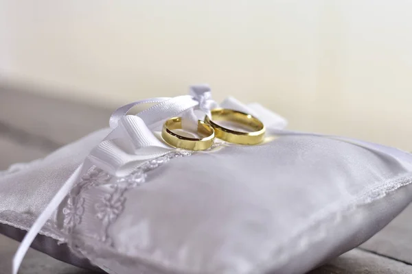 Wedding rings on a white pillow with a bow — Stock Photo, Image