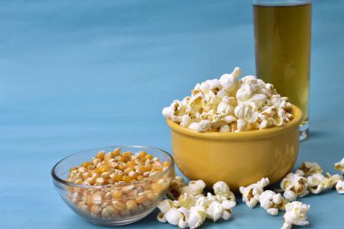 Patlamış mısır kasenin içinde. Pembe popolu. Yanında da mısır.