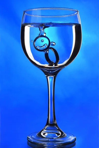 Doorschijnende drank in glas met blauwe achtergrond — Stockfoto