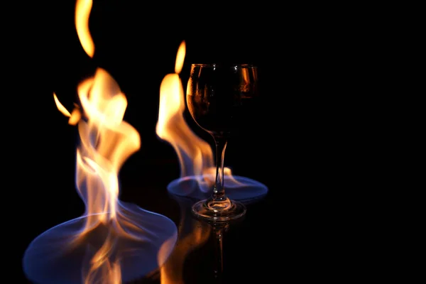 Glas Rode Wijn Glazen Tafel Met Vuur Eromheen Zwarte Achtergrond — Stockfoto