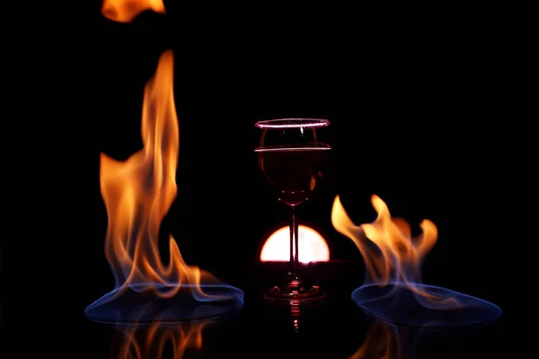 Copa Vino Tinto Mesa Cristal Con Fuego Alrededor Sobre Fondo — Foto de Stock